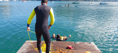 Teilnehmer:innen der Rettungsschwimm-/Schwimmlehrer:innenausbildung trainieren im Wasser