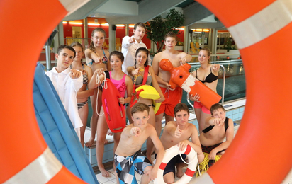 Gruppenfoto von Kindern beim Schulschwimmen durch einen Rettugnsring