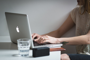 Eine Frau tippt in einen Laptop