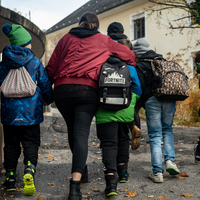 Fünf Kinder von hinten, die im schnellen Schritt gemeinsam gehen.