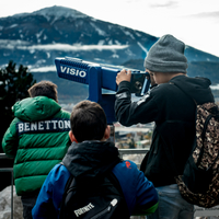 Drei Kinder schauen auf die fernen Berge.