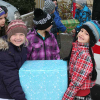 Volksschüler:innen helfen beim Beladen des Jugendrotkreuz-Transporters mit Weihnachtspaketen für bedürftige Menschen in Tirol.