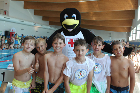 Kinder mit Pinguin beim Schwimmbewerb